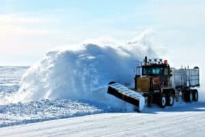 a snow removal truck is plowing snow